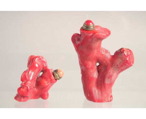 TWO CHINESE RED CORAL SNUFF BOTTLES &amp; STOPPERS, each carved in the form of Budai and a tree trunk, 3in &amp; 1.6in high. 