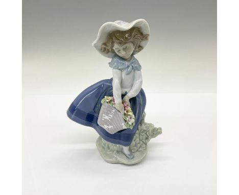 Glossy finish. Features an adorable girl with a basket of flowers. Lladro backstamp. This item has its original box: 5.5"L x 