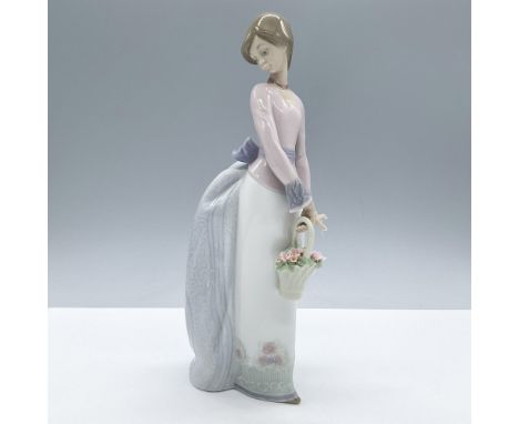 Glossy finish depiction of a young lady holding a basket of flowers and glancing over her shoulder. Lladro Collectors Society