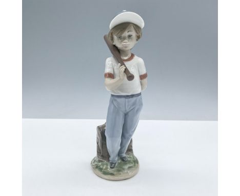Glossy finished figurine of a young boy with a baseball bat on his shoulder and a ball tucked behind his back. Lladro Collect