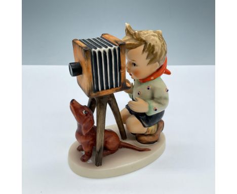 Hand painted in matte finish. A young boy takes photos with his pup by his side. Goebel Hummel backstamp. Issued: 20th centur