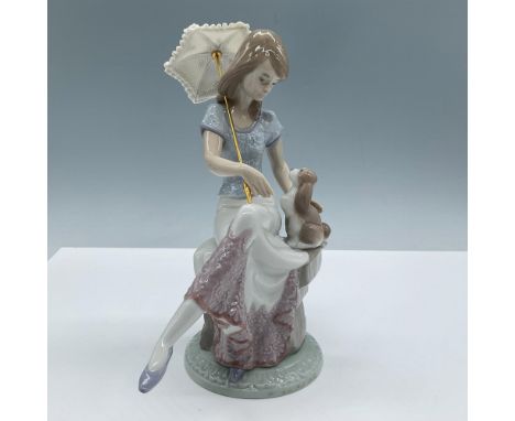 A glossy figure of a woman seated with her dog who is affectionately gazing at her. Lladro backstamp. This item has its origi