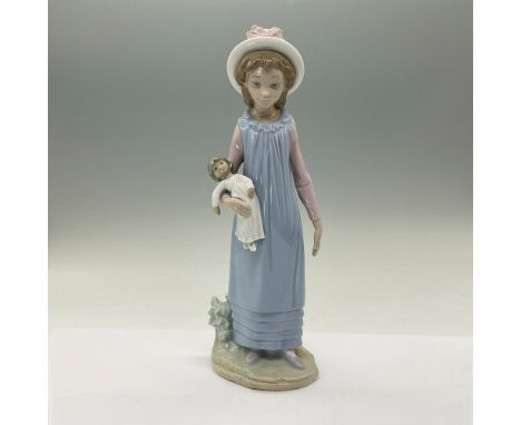 A glossy figure of a young girl holding her doll. Lladro backstamp. This item has its original box. Box measures 5.5"L x 4.5"