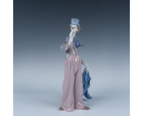 Glossy finished depiction of a clown holding his blue coat in one hand and smelling a yellow flower with the other. Lladro ba