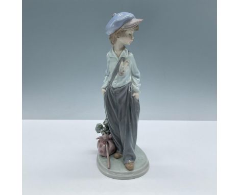 Glossy porcelain. Features a young boy with his belongings next to him, waiting for the next ride. Lladro backstamp. This ite