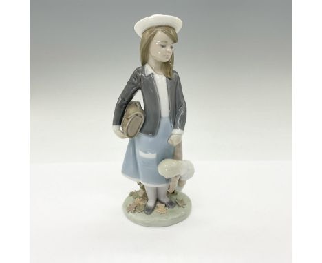 This endearing glossy glazed figurine depicts a girl holding her dolly and sack waiting. Lladro backstamp. This item has its 