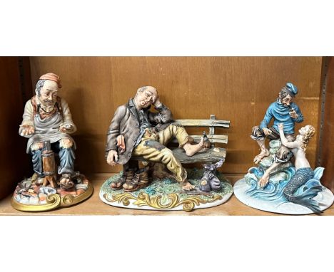 Three Capodimonte figures one homeless man on bench, a Ship Captain and Mermaid etc
