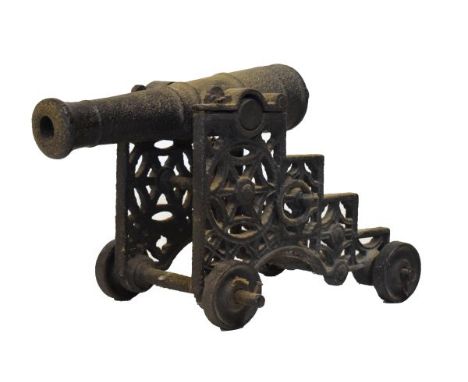 19th Century cast iron folly-cannon, with ringed 44cm barrel on pierced stepped carriage with solid wheels, total length 51cm