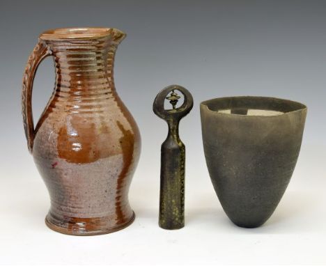 Three items of Studio pottery, comprising a brown-glazed stoneware jug of ribbed bulbous form with crimped handle, 'gunsight'
