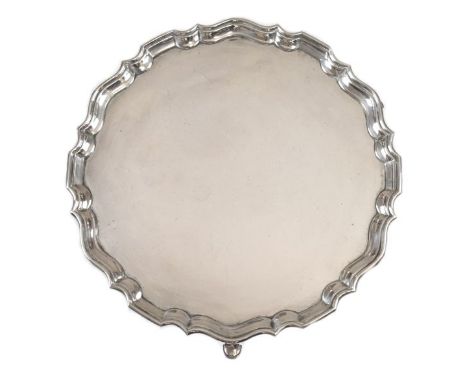 George V silver salver, with pie crust edge standing on triple pad feet, sponsors mark of Hawksworth, Eyre &amp; Co Ltd, Shef