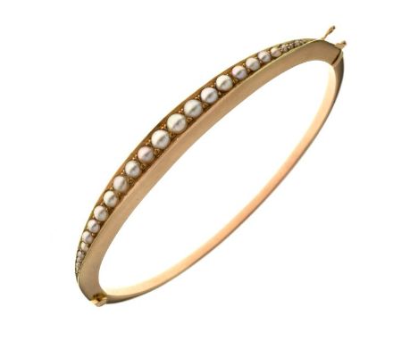 Edwardian split pearl set hinged bangle, stamped '15ct' to the catch, the frontispiece set with twenty-two split pearls (unte