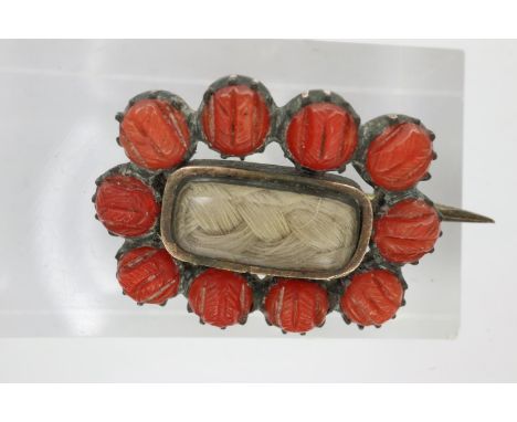 Georgian era circa 1800 brooch with braided hair, glass panel to centre with carved coral border, 15 x 20 mm, 2.4g. P&amp;P G