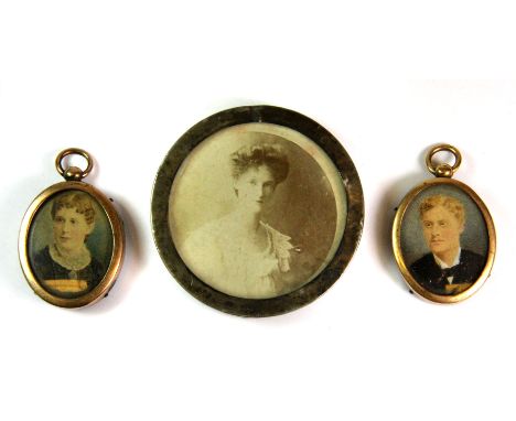 A pair of hand tinted and gilt framed photographic portrait miniatures and a further white metal framed photograph.