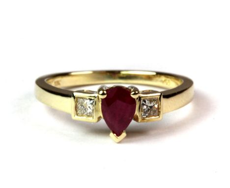 An 18ct yellow gold (stamped 750) ring set with a pear shaped ruby and two princess cut diamonds (K.5).