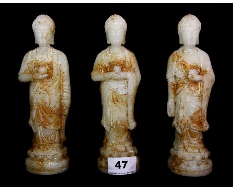 A lovely set of three Chinese carved nephrite jade figures of the standing Buddha wearing draped robes and featuring three di