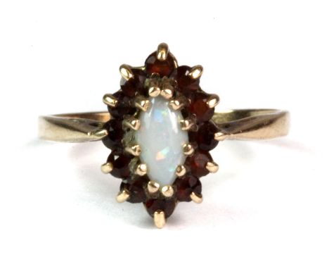 A 9ct yellow gold ring set with a centre oval cut opal surrounded by cubic zirconias (R).