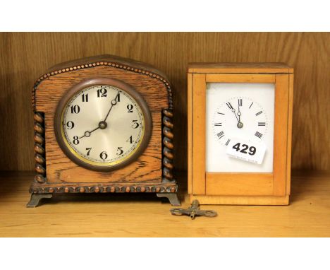 A wooden cased carriage clock movement and an oak cased mantle clock.