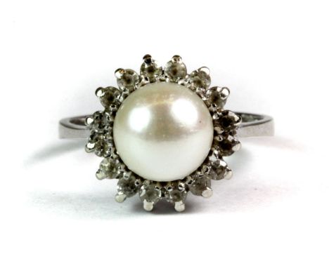 An 18ct white gold (stamped 750) ring set with a pearl surrounded by white stones (M).