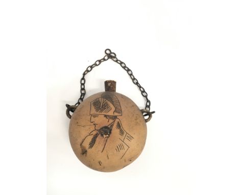 A primitive nut kernel powder flask decorated with a naive portrait of Napoleon and engraved Ajaccio on metal chain.