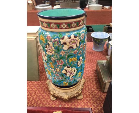 A Longwy china cylindrical vase with all-over enamel floral decoration on blue ground, mounted on period metal base (drilled)