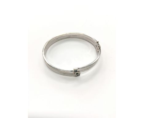 A 9 carat white gold bangle set with three blue topaz (af), (12.9 grams).