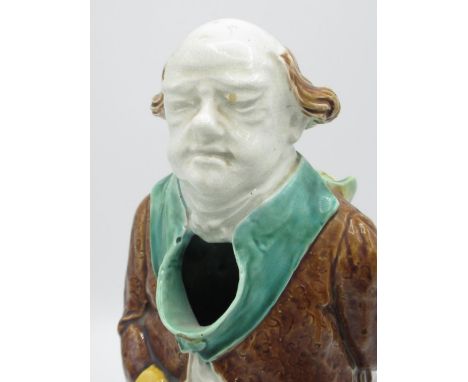 Victorian majolica jug in the form of an elderly cleric with scroll behind his back, H27.5cm, and a C19th Staffordshire Toby 