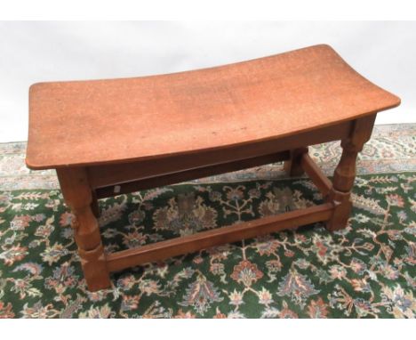 Robert Mouseman Thompson of Kilburn - an oak long stool, nailed adzed dished top on octagonal baluster supports joined by str