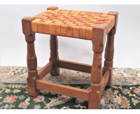 Robert Mouseman Thompson of Kilburn - an oak rectangular stool, plaited leather top on octagonal baluster supports, carved wi