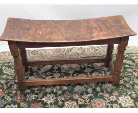 Robert Mouseman Thompson of Kilburn- an oak rectangular long stool, dished adzed top on octagonal baluster supports joined by