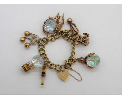 9ct yellow gold charm bracelet including carriage, trumpet, thrown, clown, hot air balloon, teapot etc with heart padlock cla