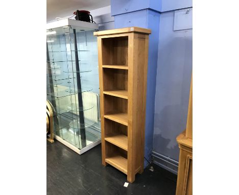 A narrow light oak bookcase