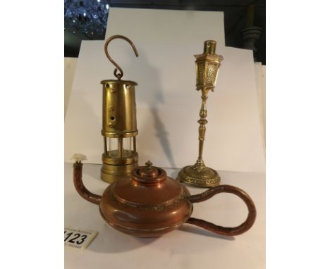 A brass miner's lamp, a copper Aladdin hand lamp and a brass street lamp lighter