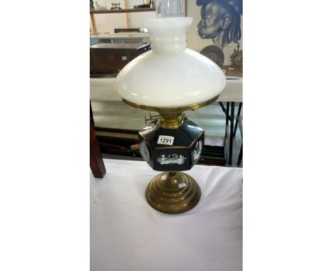 An oil lamp with ceramic font depicting Grecian scenes complete with shade and chimney