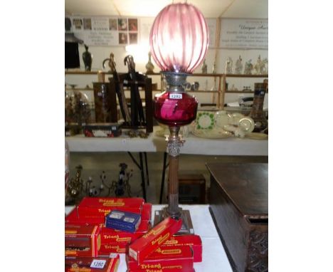 A Corinthian column oil lamp with cranberry glass font