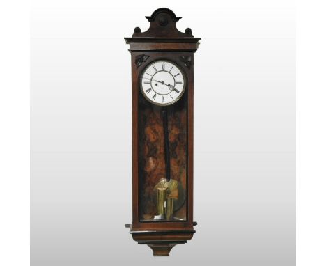 An early 20th century walnut cased vienna style wall clock, having a white enamel dial and glazed door and twin train movemen