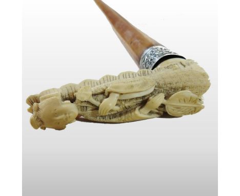 An early 20th century Chinese carved bone handled novelty walking stick, in the form of a figure, having a white metal collar