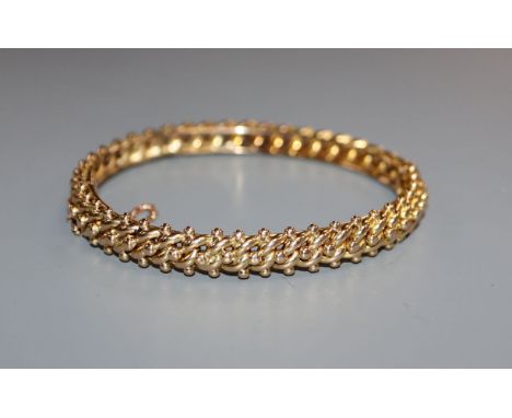 An early 20th century 15ct yellow metal hinged bangle, 19 grams.