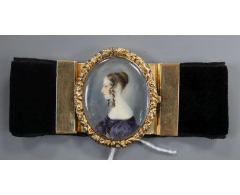 A Victorian yellow metal mounted black sash bracelet, the central clasp with miniature oval portrait of a lady.