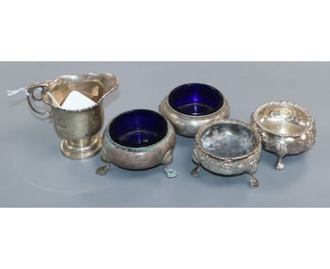 An Edwardian silver cream jug, London, 1909, a pair of Victorian silver bun slats and two other salts including Georgian.