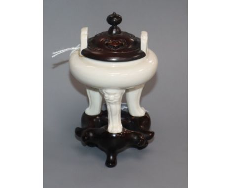 A Chinese small blanc de chine tripod censer, 17th century, wood cover and stand, repaired handle Provenance - The owner and 