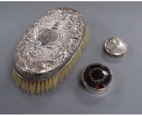 An embossed white metal clothes brush and two silver pill boxes (one a.f.).