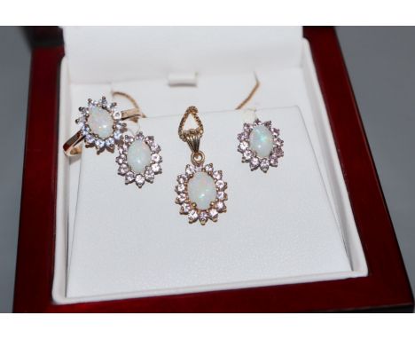 A modern suite of 9ct gold, white opal and pink sapphire jewellery, comprising, a ring, pair of earrings and a pendant neckla