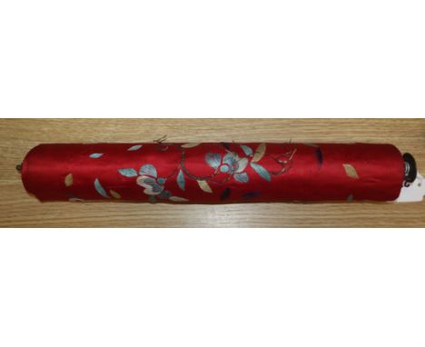 A Chinese red silk banner embroidered with figures, flowers, insects and calligraphy, on brass-mounted wooden roller (some we