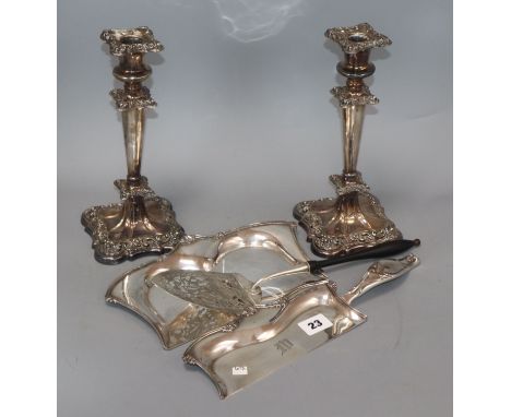 A pair of plated candlesticks, a crumb scoop and a presentation trowel