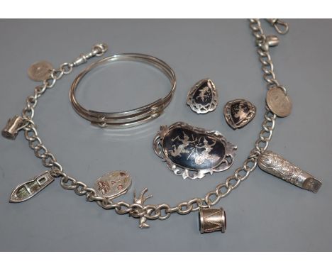 A silver charm bracelet, hung with nine charms including a Victorian locket, a 925 bangle and a Siamese sterling brooch &amp;