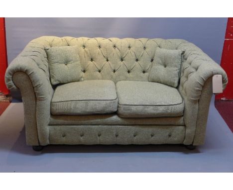 A 20th Century two seater chesterfield sofa with button back tweed upholstery raised on bun feet, H:67cm W:142cm D:84cm