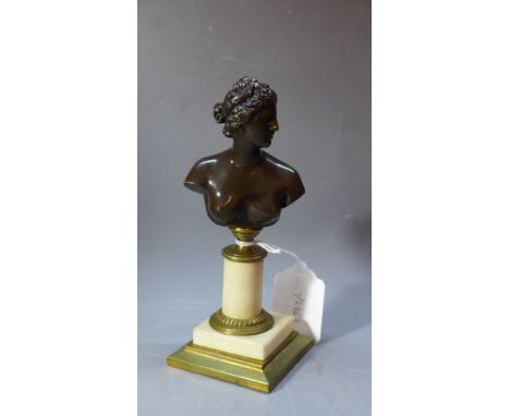 A bronze bust of a lady, signed, raised on a marble pedestal base. H.19cm 
