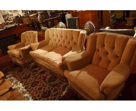 A three piece suite including two armchairs and a sofa