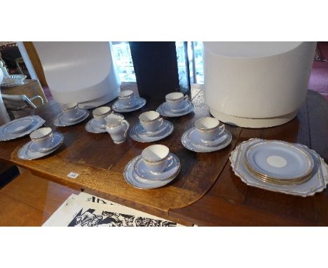 A 20th Century part tea service with eggshell blue and gilt border. 