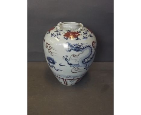 A Chinese blue and white vase with underglazed red flower decoration of a dragon chasing the flaming pearl, with four raised 